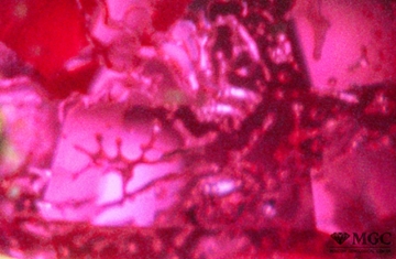 Veils of boron flux in a crack in natural ruby. View mode - dark-field lighting.