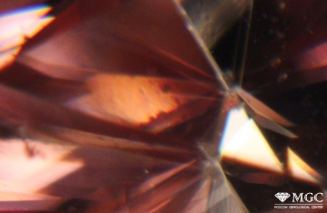 Birefringence in red synthetic moissanite. View mode - dark-field lighting