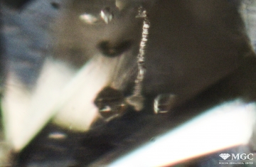 Channels of laser drilling in refined natural diamond. View mode - dark light.