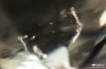 Channels of laser drilling in refined natural diamond. View mode - dark light.
