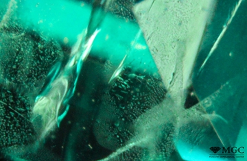 Veils and threadlike groups of two-phase inclusions in synthetic emerald. View mode - dark lighting.