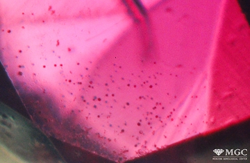 Gas bubbles and relics of the charge in synthetic ruby. Synthesis method - Vernel method. View mode - transmitted diffused light.