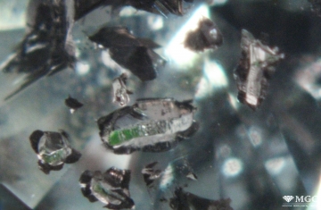 Графитизация трещин и поверхности минеральных включений в природном алмазе, подвергнутому радиационной обработке с последующим отжигом. Режим просмотра - тёмнопольное освещение.